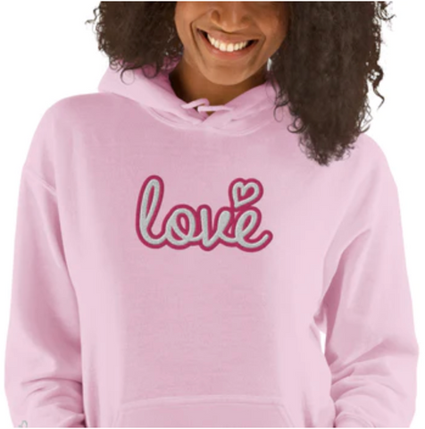 Woman wearing pink hoodie that says love